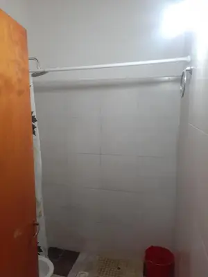 a bathroom with a toilet and a white wall at Posada clara in Cordoba
