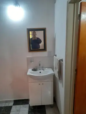 a bathroom with a sink and a picture of a man at Posada clara in Cordoba