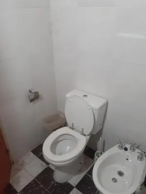 a bathroom with a white toilet and a sink at Posada clara in Cordoba