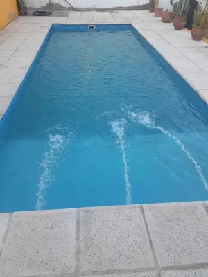 a swimming pool with blue water in a sidewalk at Posada clara in Cordoba