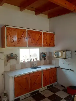 a kitchen with wooden cabinets and a sink and a window at Posada clara in Cordoba