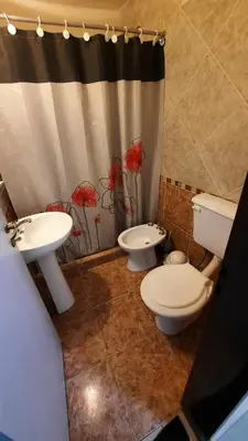 a bathroom with two toilets and a shower curtain at Alquiler de departamento céntrico en Villa Carlos Paz in Villa Carlos Paz