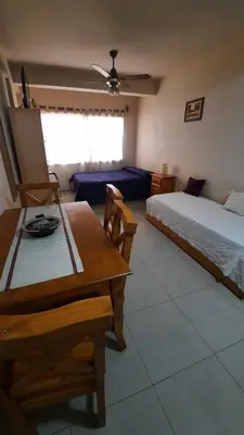 a bedroom with a bed and a table and a couch at Alquiler de departamento céntrico en Villa Carlos Paz in Villa Carlos Paz