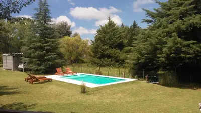 a swimming pool in a yard with two lawn chairs at Casitas del Lago in Potrero de Garay