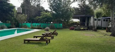 a group of benches sitting in the grass near a pool at Casitas del Lago in Potrero de Garay