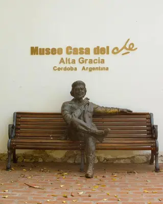 a statue of a man sitting on a bench at Flor del Aromito in Alta Gracia