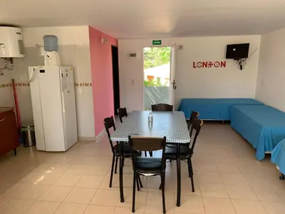 a room with a table and chairs and a kitchen at Apartamentos Dorothy in Villa Santa Cruz del Lago
