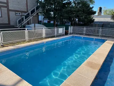 a large blue swimming pool next to a building at Apartamentos Dorothy in Villa Santa Cruz del Lago
