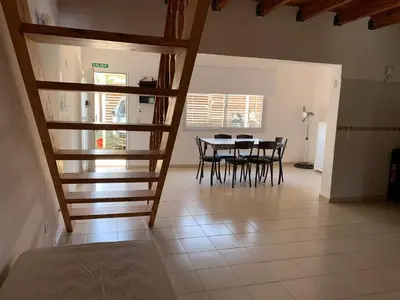 a dining room with a table and chairs and stairs at Apartamentos Dorothy in Villa Santa Cruz del Lago