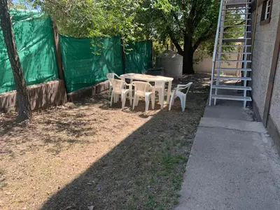 a table and chairs and a ladder next to a building at Apartamentos Dorothy in Villa Santa Cruz del Lago