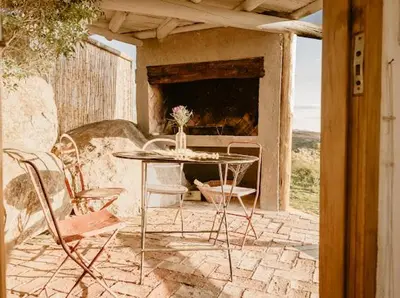 a table and chairs on a patio with a fireplace at Aldea Romerillo in Cavalango