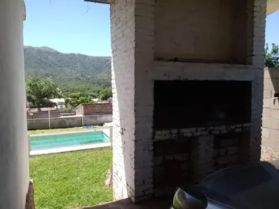 a brick fireplace with a view of a swimming pool at Mirando sierra in Bialet Massé