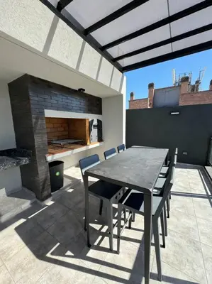 a patio with a table and chairs and a fireplace at Alquiler Ituzaingo 665 in Cordoba
