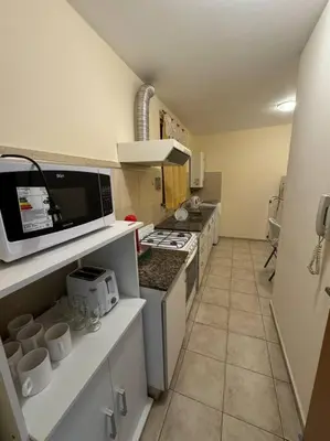 a kitchen with a stove and a microwave at Departamento 2 dormitorios in Cordoba