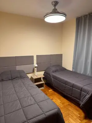 a bedroom with two beds and a lamp at Departamento 2 dormitorios in Cordoba