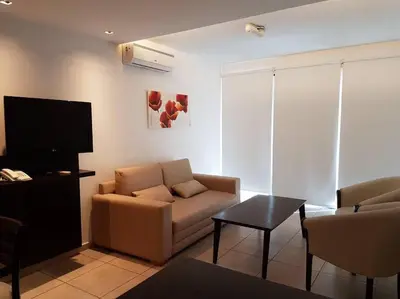 a living room with a couch and a tv at Amérian Carlos Paz Depto Particular 108 in Villa Carlos Paz