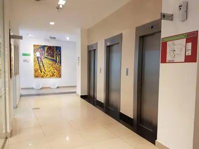 a hallway with elevators in a building with a painting at Amérian Carlos Paz Depto Particular 108 in Villa Carlos Paz
