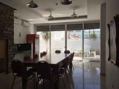 a dining room with a table and chairs and a large window at Amérian Carlos Paz Depto Particular 108 in Villa Carlos Paz