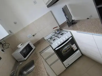 a kitchen with a stove and a microwave at TEMPO Departamento 43 in Villa Carlos Paz