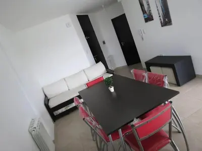 a living room with a black table and a white couch at TEMPO Departamento 43 in Villa Carlos Paz