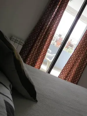 a bedroom with a bed and a large window at TEMPO Departamento 43 in Villa Carlos Paz