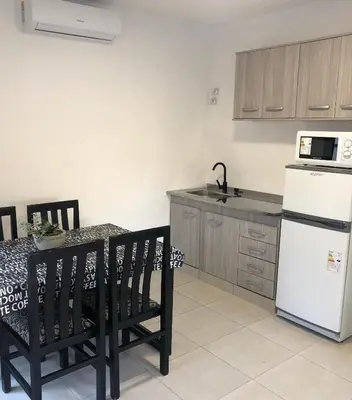 a kitchen with a white refrigerator and a table with chairs at Terra Bella in San Antonio de Arredondo