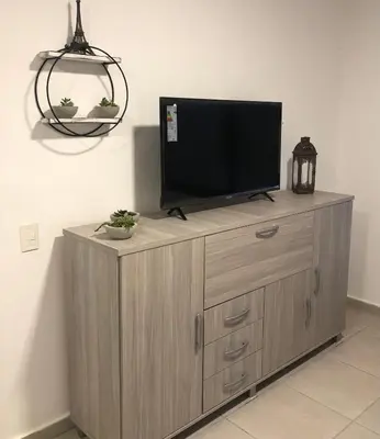a flat screen tv on top of a wooden cabinet at Terra Bella in San Antonio de Arredondo