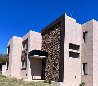 a building with a brick wall and a blue sky at Terra Bella in San Antonio de Arredondo