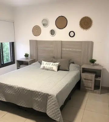 a bed in a bedroom with two tables and two mirrors at Terra Bella in San Antonio de Arredondo