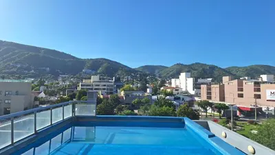 a swimming pool on the roof of a building with mountains at Terraza Terraza in Villa Carlos Paz