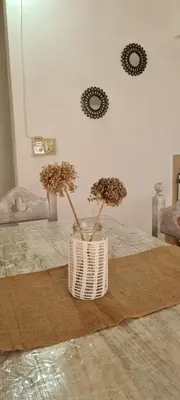 a white vase with flowers in it on a floor at Cabaña en Punilla in Villa Parque Siquiman