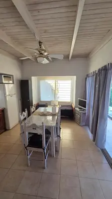 a dining room with a table and a ceiling fan at Cabaña en Punilla in Villa Parque Siquiman