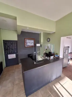 a lobby with a counter with a clock on the wall at El Redentor in Villa Carlos Paz