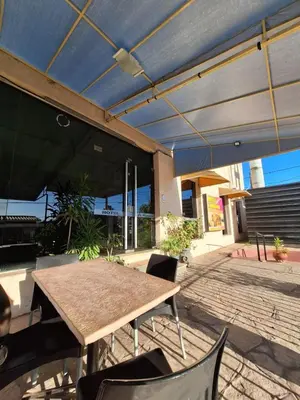 a patio with a table and chairs and a blue umbrella at El Redentor in Villa Carlos Paz