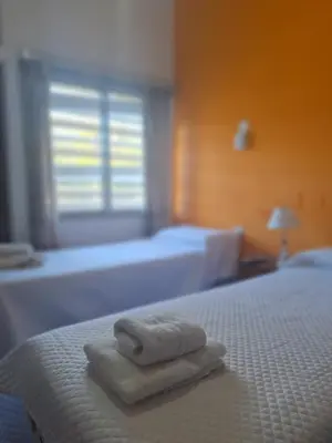 a stack of towels on a bed in a bedroom at El Redentor in Villa Carlos Paz