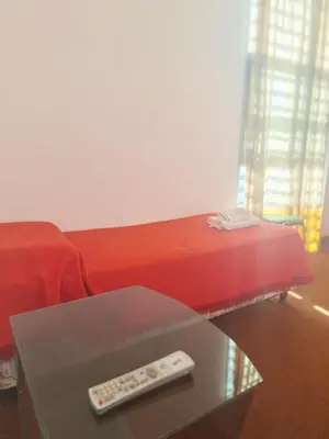 a remote control sitting on a table next to a bed at El Redentor in Villa Carlos Paz