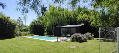 a black shed with a pool in a yard at Alquiler Casa Exclusivo Country Causana 6 Personas en Villa Carlos Paz in Villa Carlos Paz