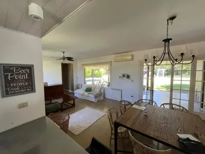a dining room and living room with a table and chairs at Alquiler Casa Exclusivo Country Causana 6 Personas en Villa Carlos Paz in Villa Carlos Paz
