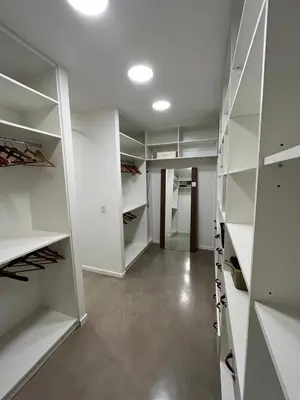 a white walk in closet with white shelves at Alquiler Casa Exclusivo Country Causana 6 Personas en Villa Carlos Paz in Villa Carlos Paz