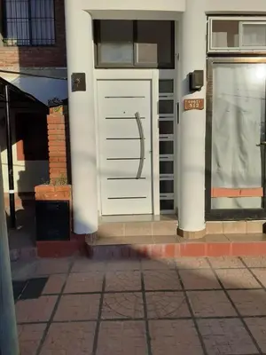 a white garage door on a building with a window at Posta Almendros Apart in Merlo
