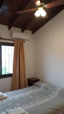 a bedroom with a ceiling fan and a bed at Posta Almendros Apart in Merlo