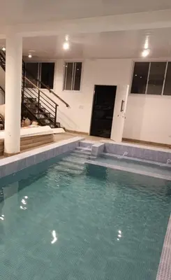a large swimming pool in a building with blue water at Posta Almendros Apart in Merlo