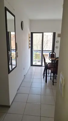 a living room with a table and chairs and windows at Departamento Temporario - Zona Centro in Cordoba