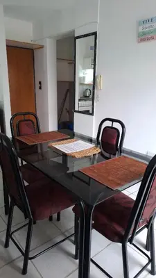 a black dining room table with chairs and a mirror at Departamento Temporario - Zona Centro in Cordoba