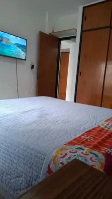 a bedroom with a bed and a tv on the wall at Departamento Temporario - Zona Centro in Cordoba