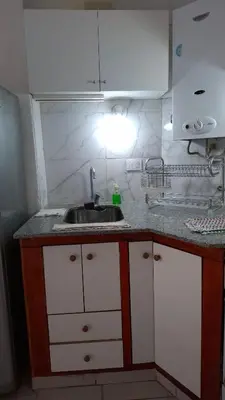 a kitchen with a sink and white cabinets at Departamento Temporario - Zona Centro in Cordoba