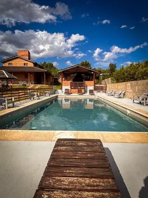 a swimming pool in front of a house at Cabañas Altos del Tintero in Mina Clavero