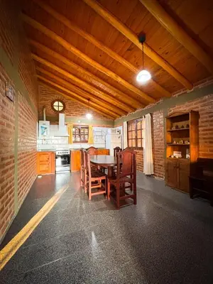 a kitchen with a table and chairs in a room at Cabañas Altos del Tintero in Mina Clavero