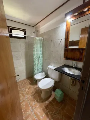a bathroom with a toilet and a sink at Cabañas Altos del Tintero in Mina Clavero