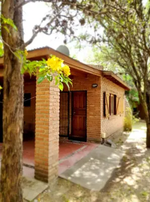 a brick house with a door and a tree at Complejo Entresierras in La Paz
